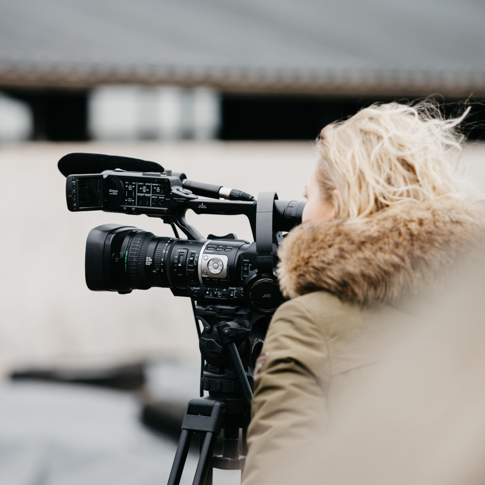 Frau schaut durch den Sucher einer Filmkamera