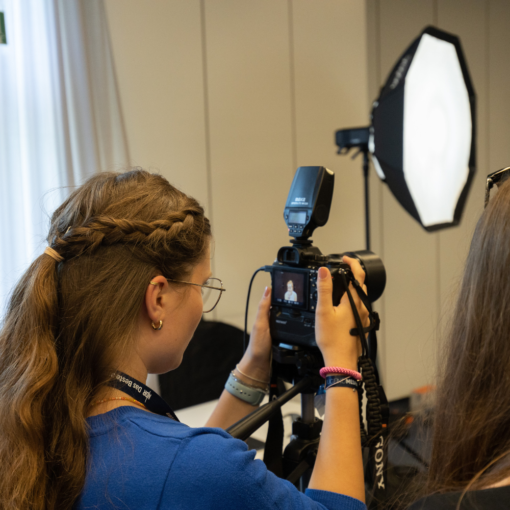 Jugendliche in blauem T-Shirt fotografiert mit professioneller Kamera und Lichtquelle