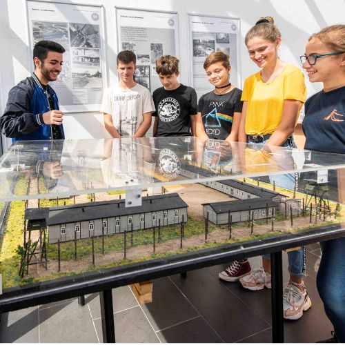 Schüler:innen vor einem Modell des KZ Kaltenkirchen