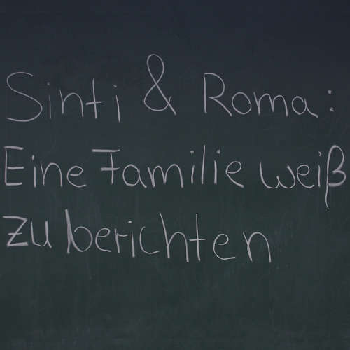 Schriftzug "Sinti & Roma: Eine Familie weiß zu berichten" mit Kreide auf einer Tafel